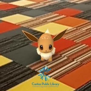 Pokemon Eevee on red, yellow, and grey checkered carpet. 