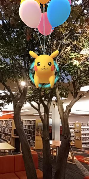 Pikachu attached to balloons, flying in the Children's tree.