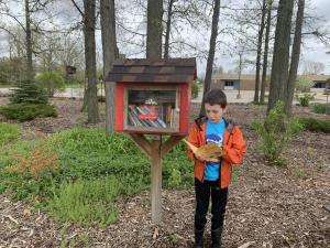 Boy visiting Little Free Library