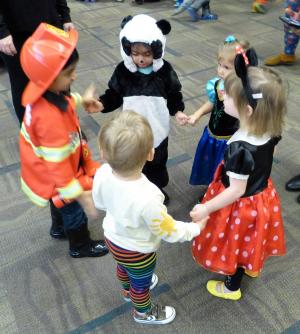 Group of costumed children dancing in circle