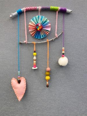 recycled craft mobile with a paper pinwheel, yarn, beads, felt, and washi tape 